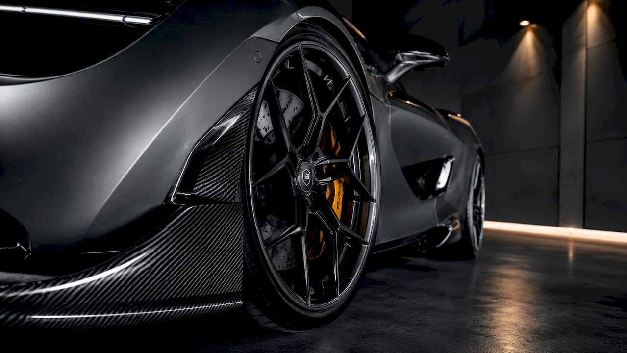 Close-up forged wheel and carbon fiber front lip spoiler