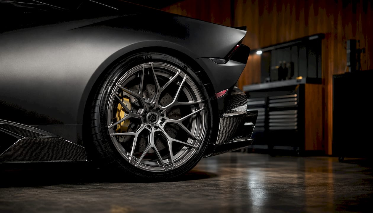Close-up forged wheel against carbon fiber fender