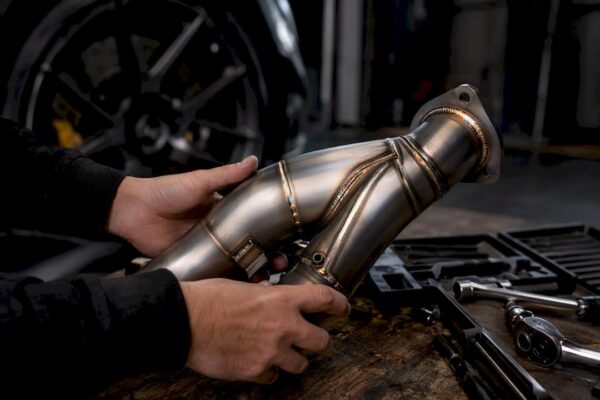 Engineer inspecting mandrel bent stainless downpipe