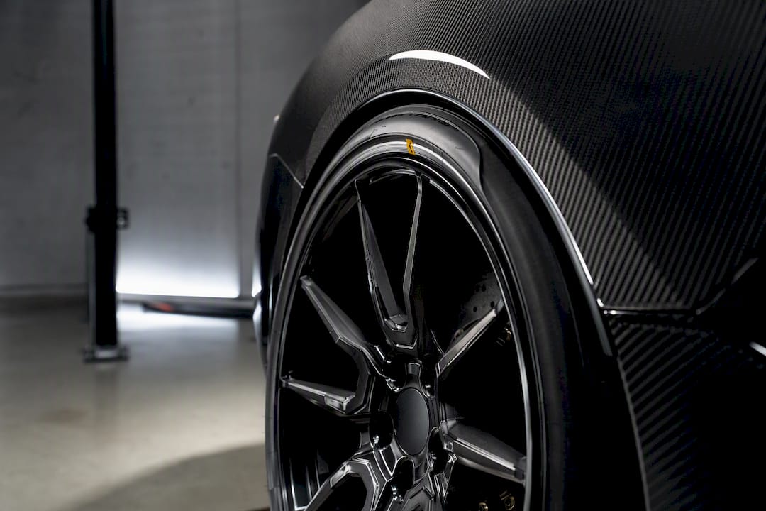Forged wheel aligned beneath vehicle fender