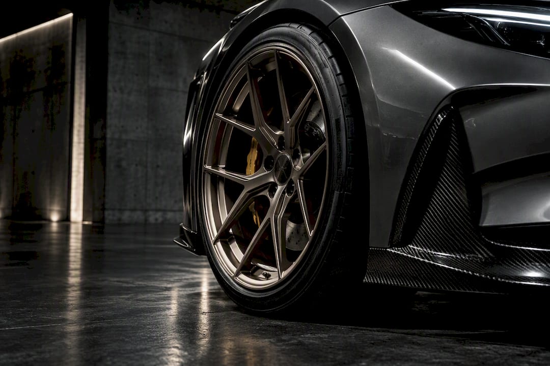 Cropped forged wheel beneath performance coupe fender